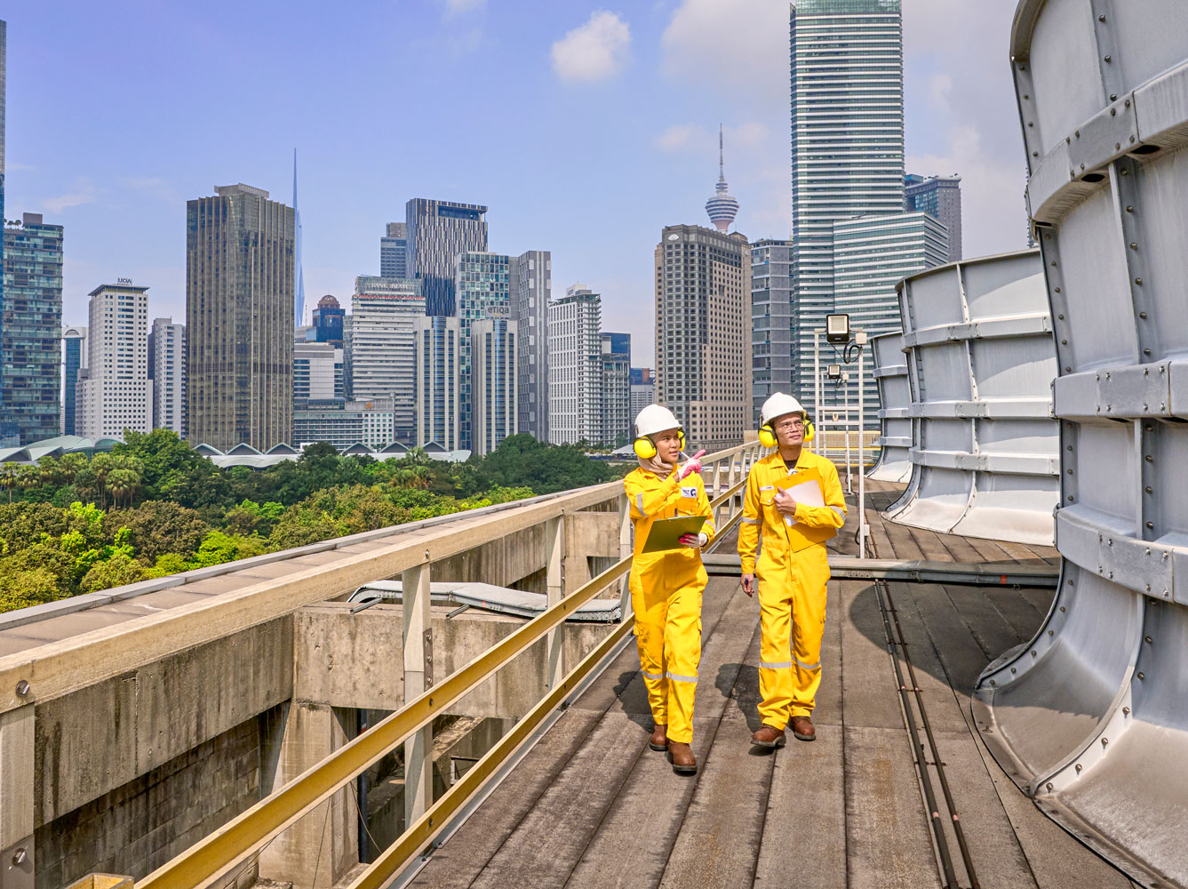 Engineers on rooftop inspecting industrial equipment, representing utilities & other businesses in a modern urban environment